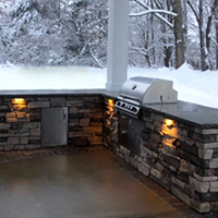 Closer View ofCustom Built Bar with Stone Masonry, Lighting, Cabinets, and Built-in Grill
